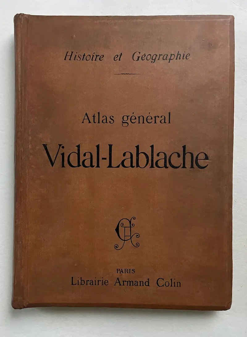Cartonnage d’éditeur « Histoire et géographie – Atlas général Vidal-Lablache » de la librairie Armand Colin après restauration, comprenant la reprise de la reliure en toile et les retouches finales de conservation des couleurs.