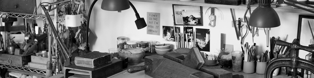 hero-ateleir-coquille-bleue Gros plan sur un espace de travail dédié à la restauration de livres anciens dans un atelier à Fontainebleau