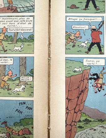 Couture fragilisée d’un album Tintin ancien, avec des fils apparents et des cahiers qui se détachent, nécessitant une restauration de la reliure.